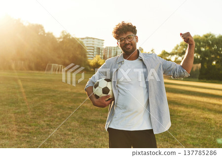 Hand up, conception of strength. Man is in the field with soccer ball Hand up, conception of strength. Man is in the field with soccer ball 137785286