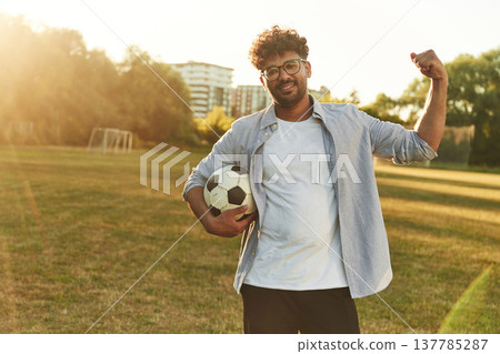 Hand up, conception of strength. Man is in the field with soccer ball Hand up, conception of strength. Man is in the field with soccer ball 137785287