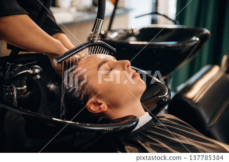 Doing all the washing. Woman is in a beauty salon with hair stylist Doing all the washing. Woman is in a beauty salon with hair stylist 137785384