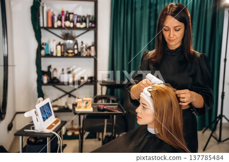 Washing the head. Woman is in a beauty salon with hair stylist 137785484