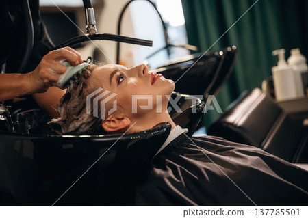Healthy massage for the head and skin. Woman is in a beauty salon with hair stylist Healthy massage for the head and skin. Woman is in a beauty salon with hair stylist 137785501