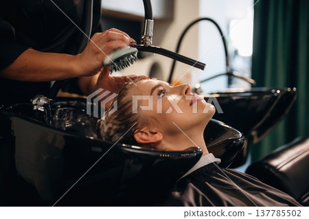 Healthy massage for the head and skin. Woman is in a beauty salon with hair stylist Healthy massage for the head and skin. Woman is in a beauty salon with hair stylist 137785502