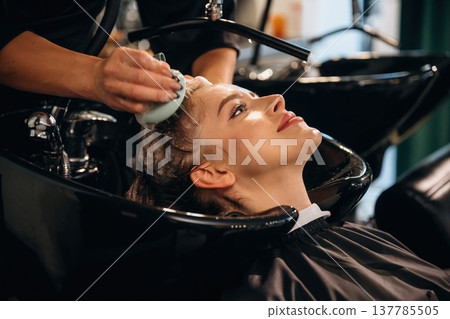 Healthy massage for the head and skin. Woman is in a beauty salon with hair stylist Healthy massage for the head and skin. Woman is in a beauty salon with hair stylist 137785505