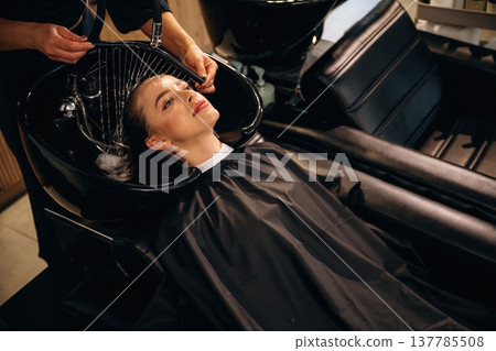 Clean water, washing hair. Woman is in a beauty salon with hair stylist Clean water, washing hair. Woman is in a beauty salon with hair stylist 137785508