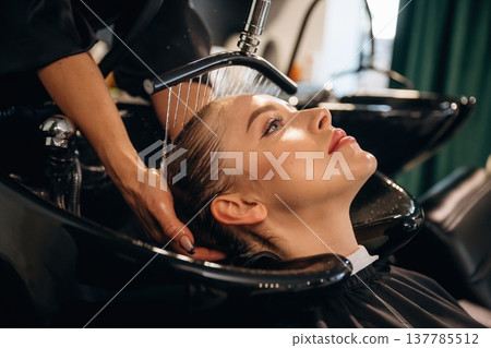 Service for customer, washing head. Woman is in a beauty salon with hair stylist Service for customer, washing head. Woman is in a beauty salon with hair stylist 137785512