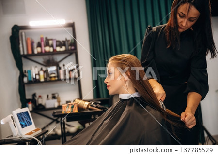 Finishing moves. Woman is in a beauty salon with hair stylist 137785529