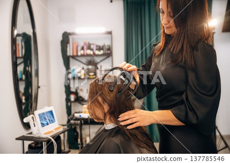 Pleasant massage for head. Woman is in a beauty salon with hair stylist Pleasant massage for head. Woman is in a beauty salon with hair stylist 137785546