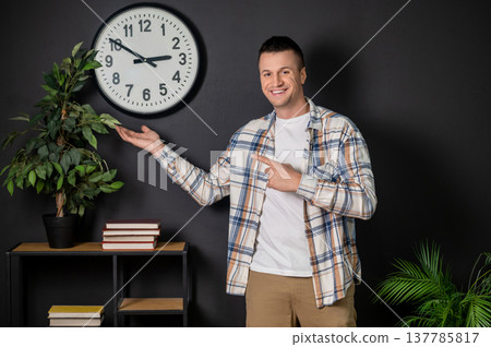 Happy man presenting and pointing with hands posing in modern office interior Happy man presenting and pointing with hands posing in modern office interior 137785817