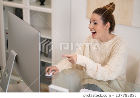 Woman in white warm sweater at home working at the table 137785855