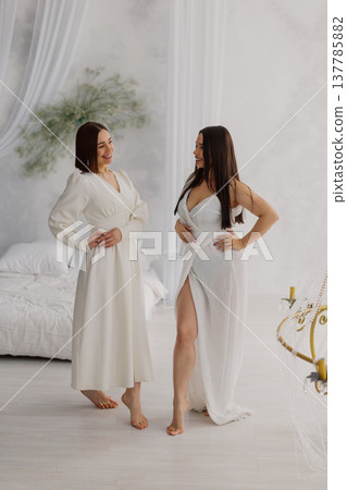Two beautiful women in long dresses in the studio 137785882