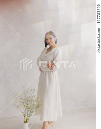 Young beautiful woman posing near white wall 137785896
