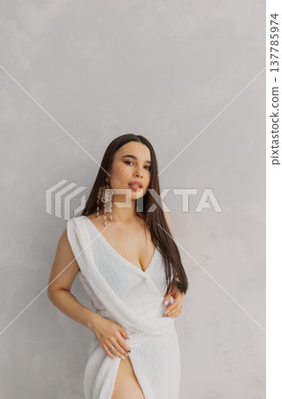 Young beautiful woman posing near white wall 137785974