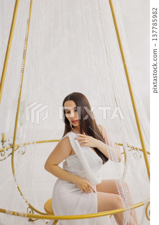 Young beautiful woman posing near gilded crystal Young beautiful woman posing near gilded crystal 137785982
