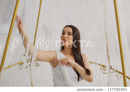 Young beautiful woman posing near gilded crystal Young beautiful woman posing near gilded crystal 137785983