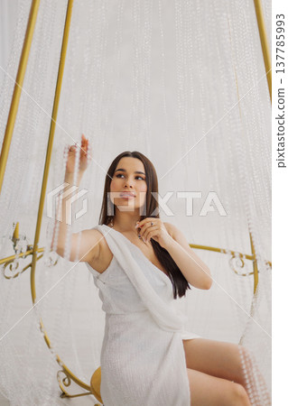 Young beautiful woman posing near gilded crystal Young beautiful woman posing near gilded crystal 137785993