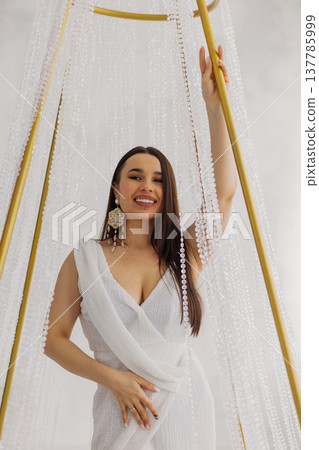 Young beautiful woman posing near gilded crystal Young beautiful woman posing near gilded crystal 137785999