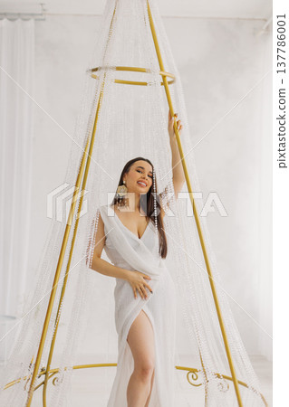 Young beautiful woman posing near gilded crystal Young beautiful woman posing near gilded crystal 137786001