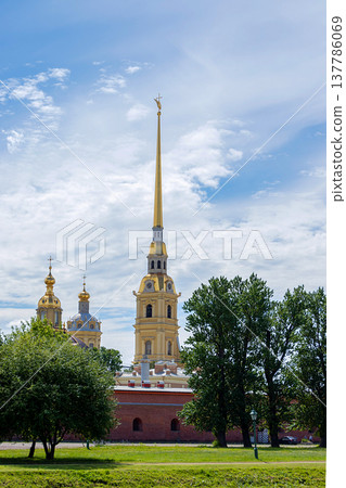 Russia, St. Petersburg, July 3, 2020, Peter and Paul Fortress .. The photo shows the Peter and Paul Fortress close-up among the trees, view from the arrow of Vasilyevsky Island Russia, St. Petersburg, July 3, 2020, Peter and Paul Fortress .. The photo shows the Peter and Paul Fortress close-up among the trees, view from the arrow of Vasilyevsky Island 137786069