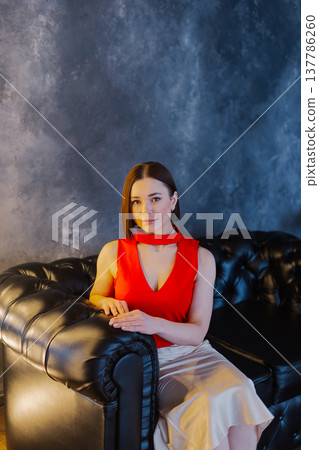 Young beautiful woman posing on leather sofa Young beautiful woman posing on leather sofa 137786260