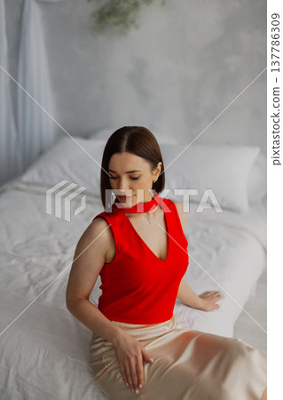 Young beautiful woman posing on a luxurious bed Young beautiful woman posing on a luxurious bed 137786309