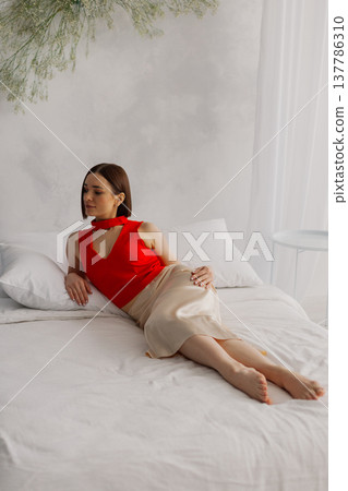 Young beautiful woman posing on a luxurious bed Young beautiful woman posing on a luxurious bed 137786310