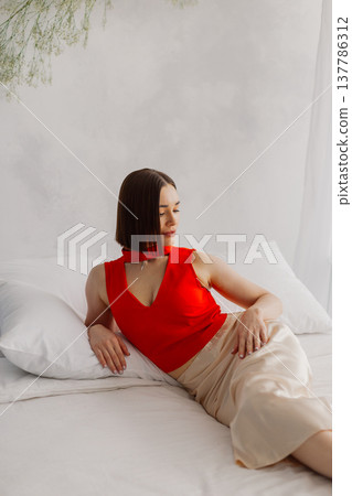 Young beautiful woman posing on a luxurious bed Young beautiful woman posing on a luxurious bed 137786312