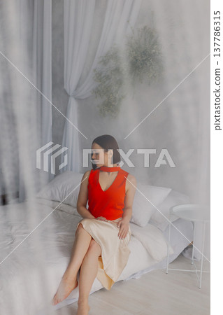 Young beautiful woman posing on a luxurious bed Young beautiful woman posing on a luxurious bed 137786315