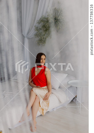 Young beautiful woman posing on a luxurious bed 137786316