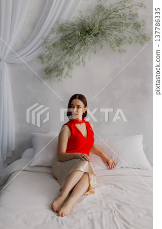 Young beautiful woman posing on a luxurious bed Young beautiful woman posing on a luxurious bed 137786335