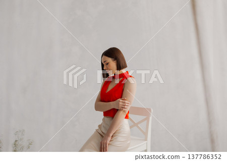Young beautiful woman posing on wooden chair 137786352