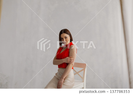 Young beautiful woman posing on wooden chair Young beautiful woman posing on wooden chair 137786353