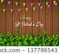 Happy St. Patrick's Day with green shamrocks above wooden background 137786543