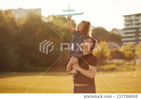 Imagination conception, with toy plane, flying. Father with his little daughter are on the field Imagination conception, with toy plane, flying. Father with his little daughter are on the field 137786688