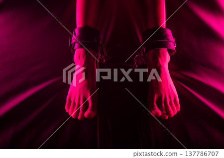 Women's legs in leather shackles. BDSM fetish. 137786707