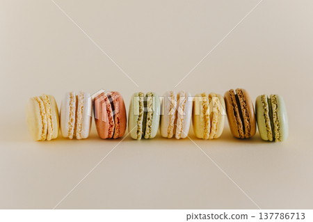 Tasty french macarons on a peach pastel background. Tasty french macarons on a peach pastel background. 137786713