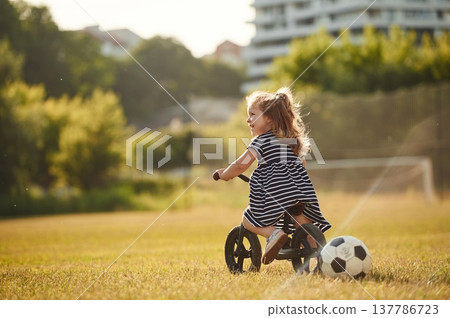 Cute little girl is on the field at daytime Cute little girl is on the field at daytime 137786723