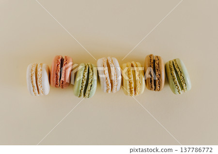 Tasty french macarons on a peach pastel background. Tasty french macarons on a peach pastel background. 137786772
