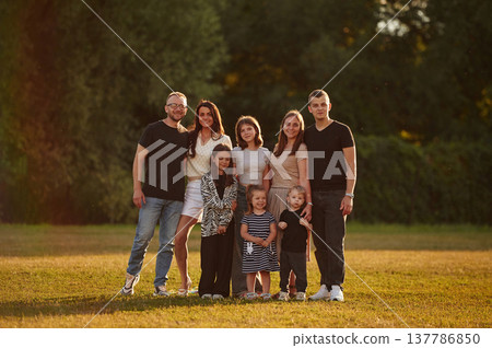 Looking forward. Family with adults and kids is standing on the field Looking forward. Family with adults and kids is standing on the field 137786850