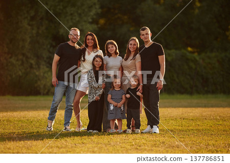 Looking forward. Family with adults and kids is standing on the field 137786851