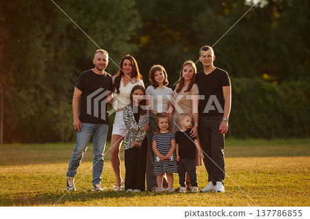 Family with adults and kids is standing on the field Family with adults and kids is standing on the field 137786855