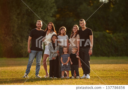 Family with adults and kids is standing on the field Family with adults and kids is standing on the field 137786856