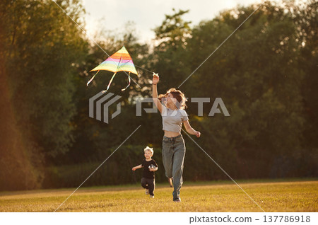 Sister and her little brother, with kite. Two kids are having fun on the summer field 137786918
