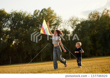 Sister and her little brother, with kite. Two kids are having fun on the summer field 137786920