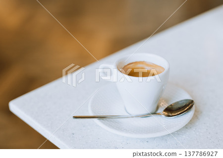 Cup of black coffee on a table in a cafe. Cup of black coffee on a table in a cafe. 137786927