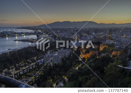 Views of Malaga at sunset with the city lights and harbor in the background Views of Malaga at sunset with the city lights and harbor in the background 137787140