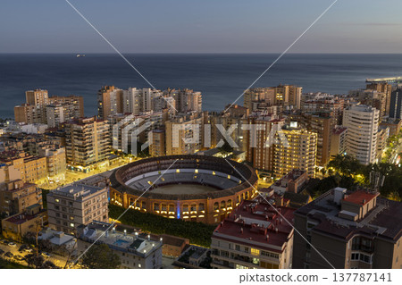 City view of Malaga Spain with the bullring at sunset near the coast and tall buildings in the background City view of Malaga Spain with the bullring at sunset near the coast and tall buildings in the background 137787141