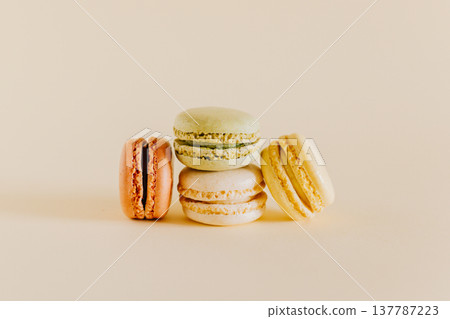Tasty french macarons on a peach pastel background. Tasty french macarons on a peach pastel background. 137787223