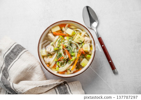 Chicken noodle soup with fresh dill in a bowl on a light textured background Chicken noodle soup with fresh dill in a bowl on a light textured background 137787297