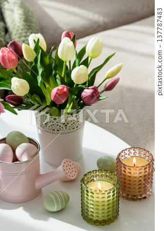 Easter Table with Tulip Bouquets, Eggs, Candles and Festive Decor. Cozy Spring Arrangement Easter Table with Tulip Bouquets, Eggs, Candles and Festive Decor. Cozy Spring Arrangement 137787483