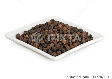 Black peppercorns or pepper in a ceramic bowl isolated on a white background 137787681